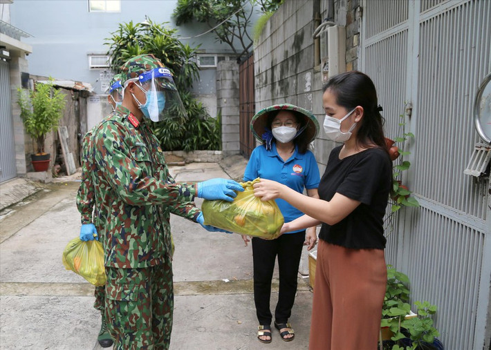 Những túi thực phẩm được đưa đến từng nhà dân trong hẻm nhỏ để hạn chế tối đa việc tiếp xúc và tập trung đông người trong đợt siết chặt giãn cách. (Ảnh: Tiền Phong)