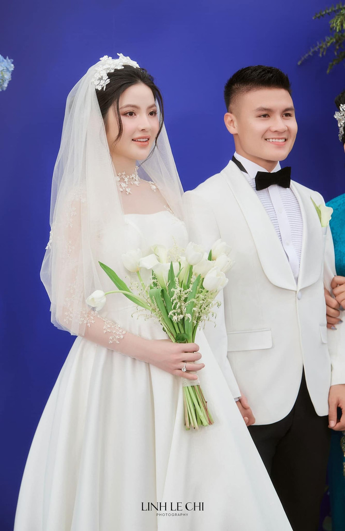 Cô dâu búi tóc cao, đội voan ngắn ngang lưng. Chất liệu lụa giúp Chu Thanh Huyền dễ dàng di chuyển khi đón khách. Ảnh: Lê Chí Linh.