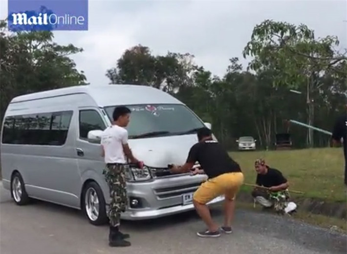 Bốn người đàn ông này dùng gậy dài từ từ cạy cốp xe.