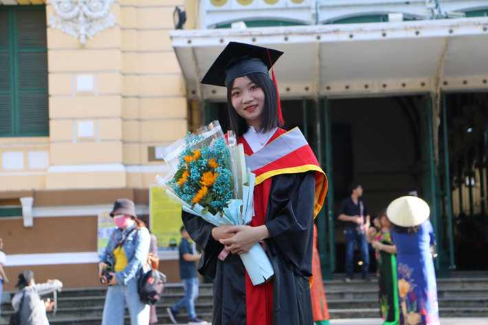 Bạn trẻ chụp ảnh lưu niệm với bộ lễ phục tốt nghiệp.
