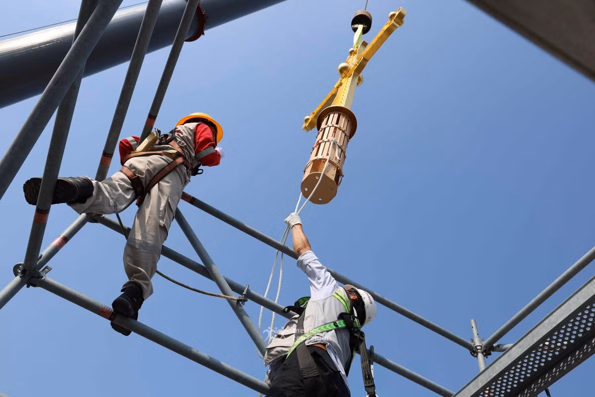 Thánh giá được cần cẩu chuyên dụng đưa lên độ cao hơn 60m, sau đó hạ dần xuống vị trí đỉnh tháp kẽm bên phải của tháp chuông Nhà thờ Đức Bà Sài Gòn