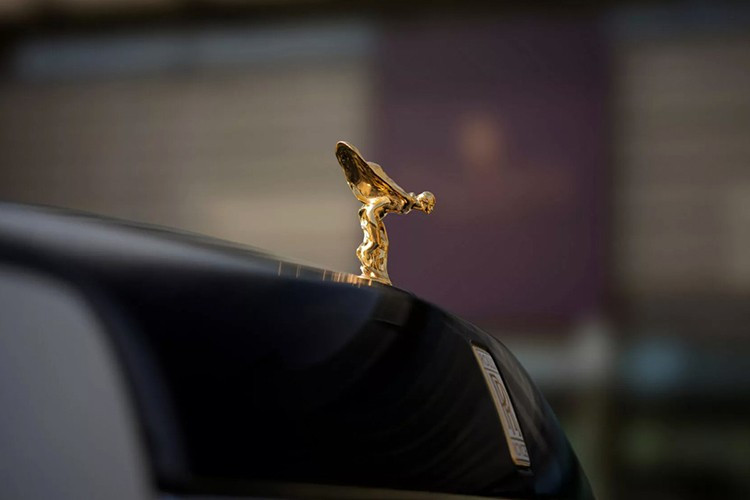 Trên nắp capo, biểu tượng Spirit of Ecstasy được chế tác từ vàng khối 18K và mạ thêm vàng 24K chống xỉn màu. Bệ đỡ tượng được đúc tay bằng men trắng, khắc dòng chữ Phantom Centenary.