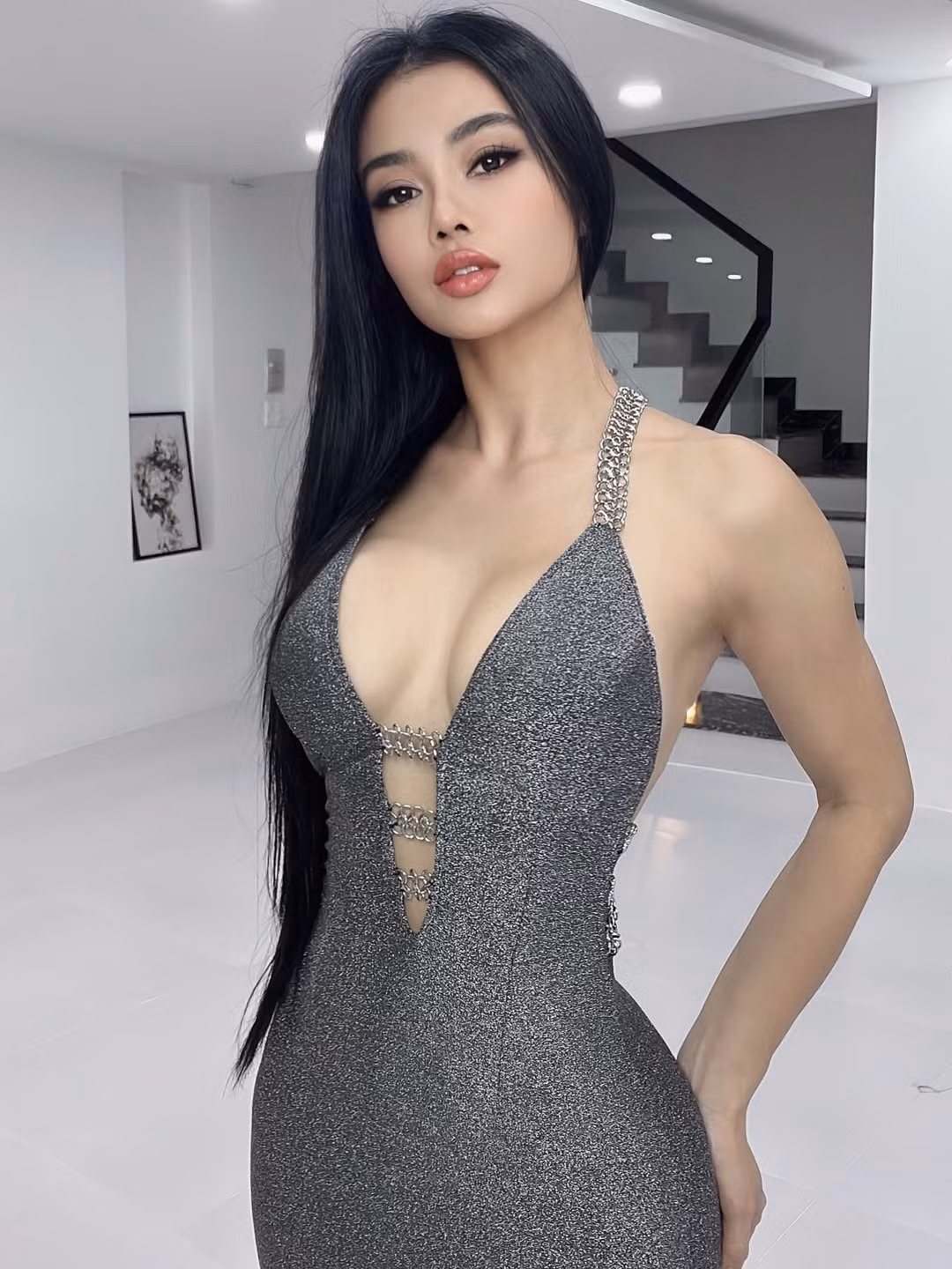 Trong loạt ảnh, Julia Hồ khoác lên mình bộ váy metallic ôm sát, phom dáng cut-out sâu hun hút khoe trọn phần lưng trần cùng vòng 1 đầy đặn. Chất liệu ánh bạc kết hợp dây xích kim loại ở vai và phần thân tạo nên vẻ đẹp quyến rũ mà mạnh mẽ, đúng chất “nữ hoàng gợi cảm” của Vbiz.