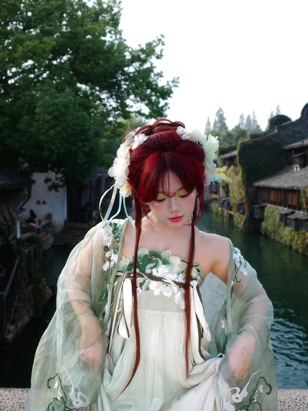 Bộ trang phục mà Bảo Hân lựa chọn mang tông xanh ngọc chủ đạo, chất liệu voan mềm và bay, rất phù hợp với khung cảnh sông nước cổ trấn. Họa tiết thêu hoa trắng – vàng tinh xảo chạy dọc thân và tay áo tạo nên vẻ nữ tính, thanh lịch.