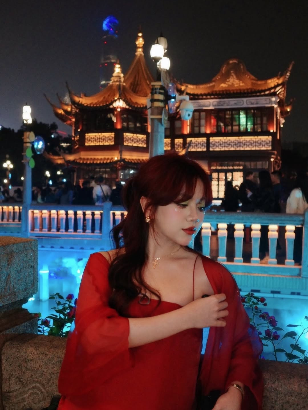 Mái tóc đỏ trầm được tạo kiểu uốn nhẹ, kết hợp layout makeup tông cam – hồng trong trẻo, nhấn vào đôi môi căng mọng và đôi mắt long lanh, khiến tổng thể diện mạo của Bảo Hân Helia trở nên vô cùng cuốn hút dưới ánh đèn đêm.