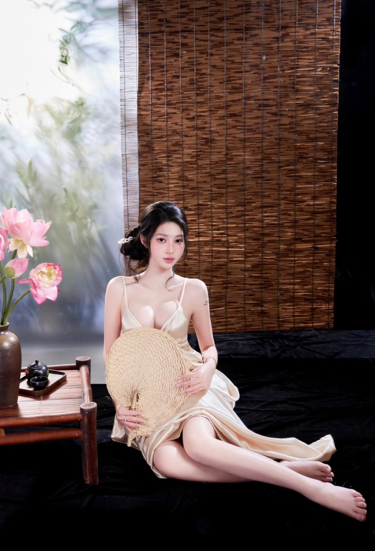 Tư thế ngồi tựa bên bàn trà, tay nhẹ nhàng chạm vào cánh sen, hay ánh mắt nhìn xa xăm đều toát lên thần thái vừa dịu dàng, thơ mộng, vừa ẩn chứa sức hút mãnh liệt, khiến ai nhìn vào cũng phải trầm trồ.