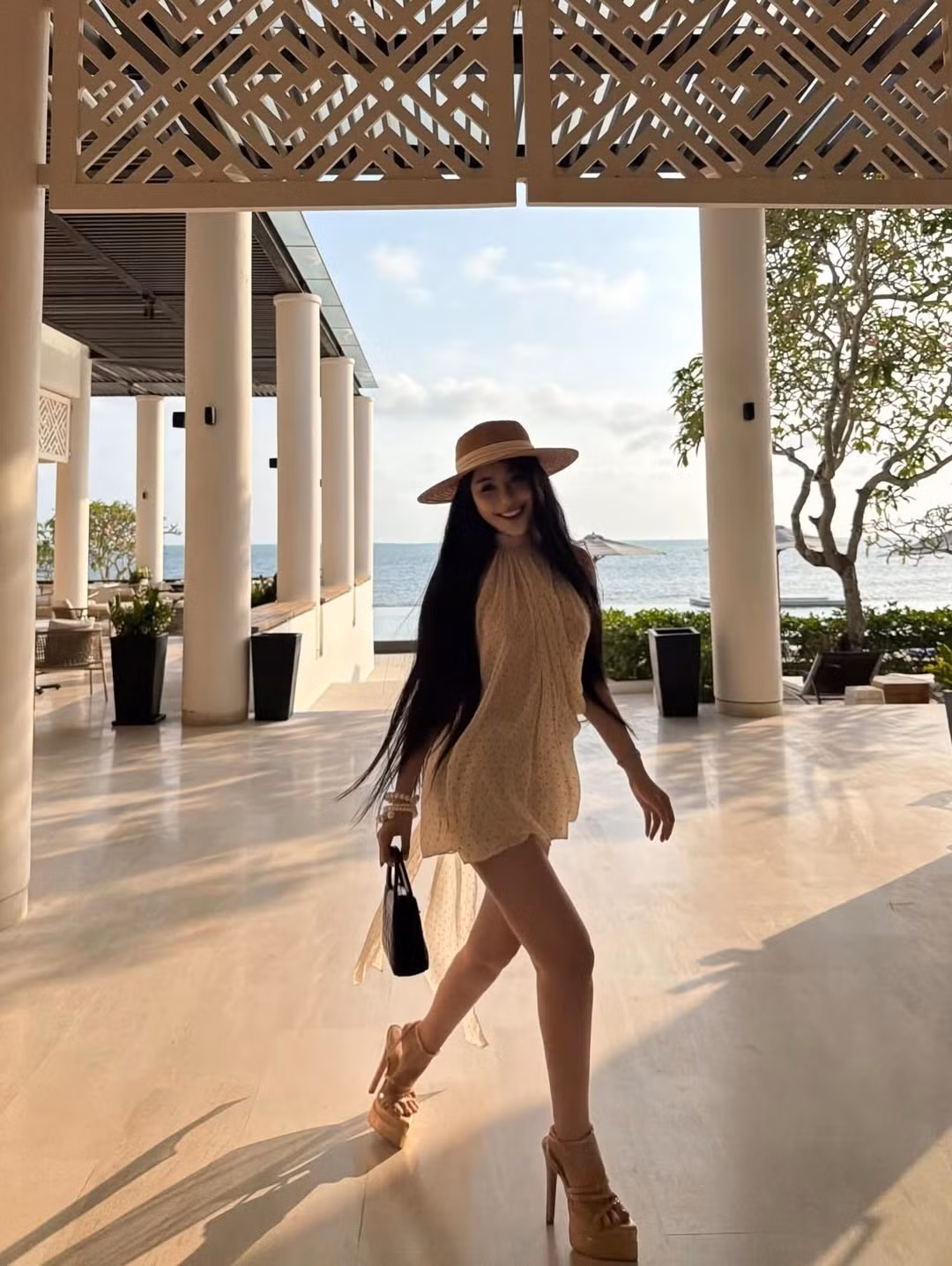 Không chỉ ghi điểm nhờ trang phục, cách cô phối phụ kiện cũng nhận được nhiều lời khen. Mũ cói và túi xách tông trầm mang hơi hướng resort wear đặc trưng, tạo nên hình ảnh một quý cô đang tận hưởng kỳ nghỉ sang chảnh đúng nghĩa. Những món trang sức ngọc trai và vòng tay ánh kim được tiết chế vừa đủ, giúp tổng thể không bị rườm rà nhưng vẫn toát lên vẻ sang trọng.