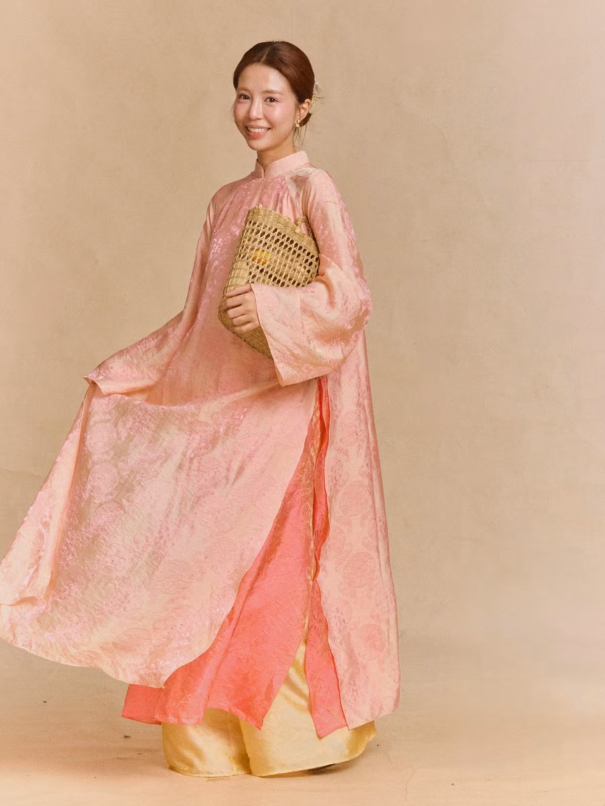 Hình ảnh người đẹp tay nâng cành hoa, nở nụ cười rạng rỡ giữa phông nền tối giản càng làm nổi bật tinh thần an yên, nhẹ nhàng – điều mà nhiều người luôn tìm kiếm trong những ngày đầu năm mới.