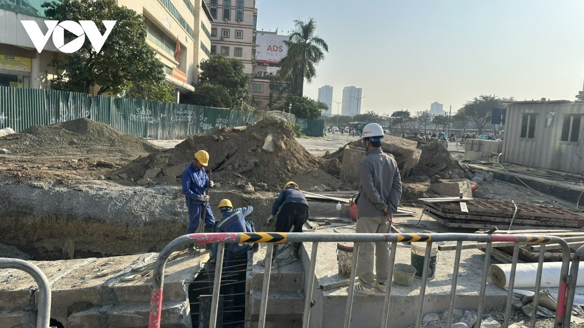 Công nhân đang khẩn trương thi công trên mặt đường Giải Phóng lối rẽ vào phố Kim Đồng.