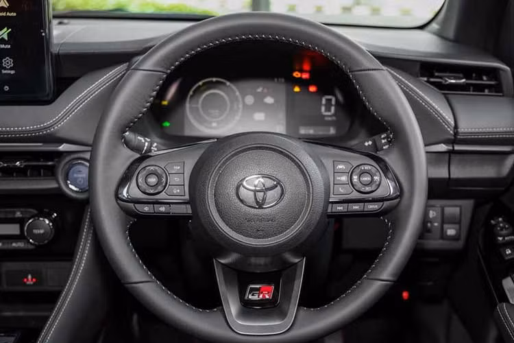 Cụm đồng hồ kỹ thuật số 7 inch của Toyota Vios Hybrid 2026 sẽ có thêm giao diện riêng cho hệ truyền động hybrid. Bản GR Sport có nội thất đen toàn bộ, điểm nhấn là vô-lăng và ghế thể thao thêu logo GR, kết hợp da và chất liệu suede.