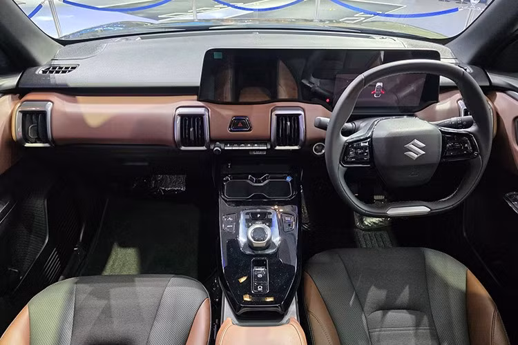 Bên trong, Suzuki e Vitara gây ấn tượng với thiết kế hiện đại, trong đó có hai màn hình cỡ lớn liền mạch nổi trên táp-lô và vô lăng hai chấu vát đáy tích hợp phím chức năng, các cửa gió điều hòa hình vuông viền bạ.