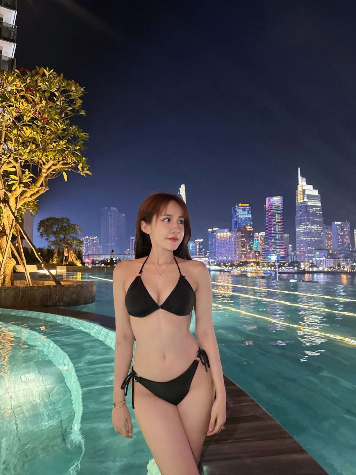 Trong bức ảnh, Tuyết Anh ngồi hờ hững bên thành bể bơi, mái tóc dài màu nâu hạt dẻ buông xõa lãng mạn, khuôn mặt trang điểm nhẹ nhàng nhưng nổi bật với nụ cười ngọt ngào và ánh mắt tươi tắn hướng về phía trước.