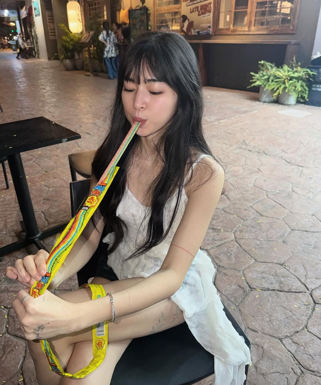 Chiếc váy hai dây trắng nhẹ nhàng kết hợp với nụ cười tươi, đôi mắt long lanh khiến hình ảnh của Khánh Vân đơn giản nhưng cuốn hút. Giữa bối cảnh phố đêm với ánh đèn vàng và dòng người tấp nập, nữ diễn viên vẫn nổi bật nhờ sự trẻ trung, tự nhiên và phong thái thoải mái.