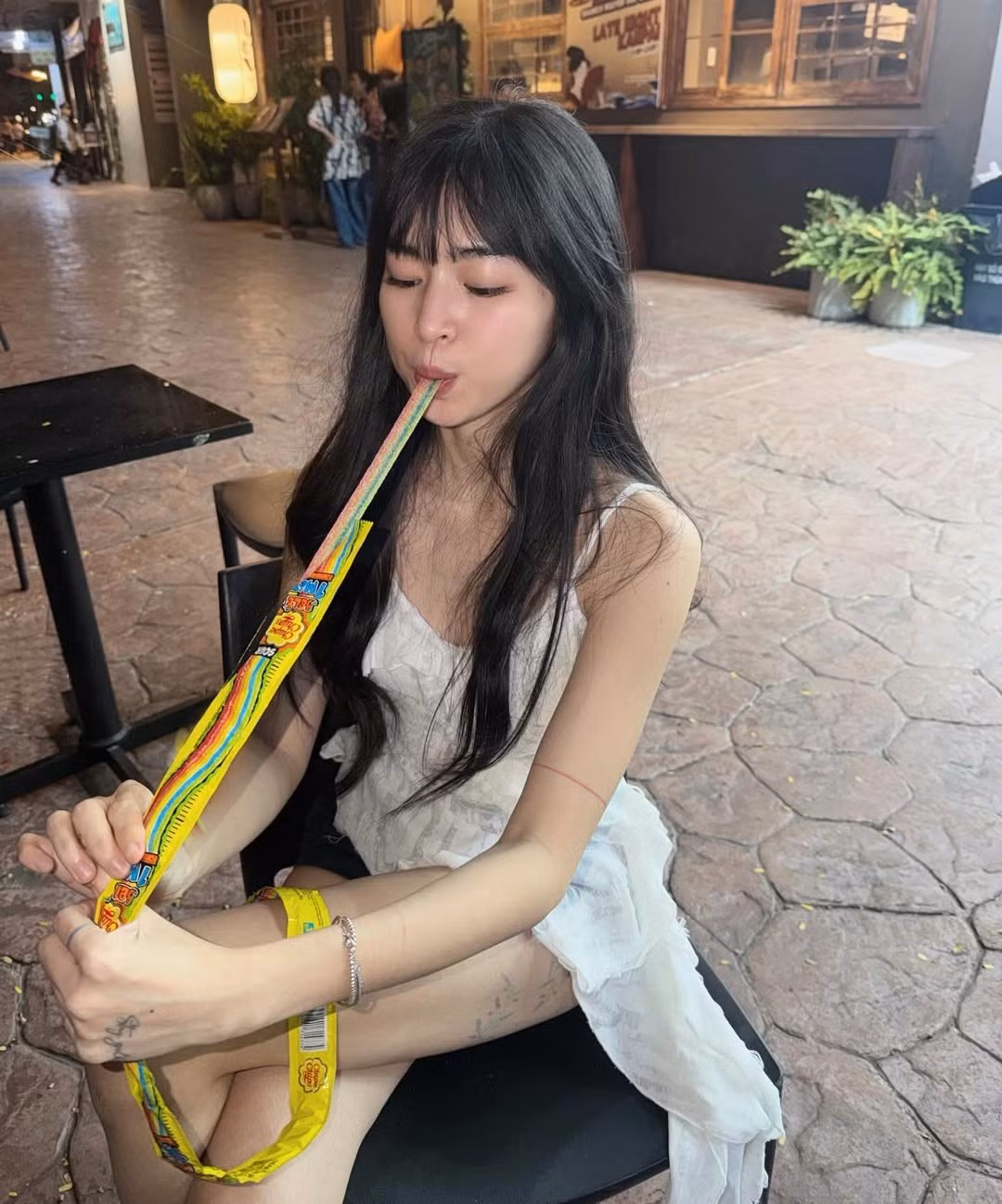 Chiếc váy hai dây trắng nhẹ nhàng kết hợp với nụ cười tươi, đôi mắt long lanh khiến hình ảnh của Khánh Vân đơn giản nhưng cuốn hút. Giữa bối cảnh phố đêm với ánh đèn vàng và dòng người tấp nập, nữ diễn viên vẫn nổi bật nhờ sự trẻ trung, tự nhiên và phong thái thoải mái.