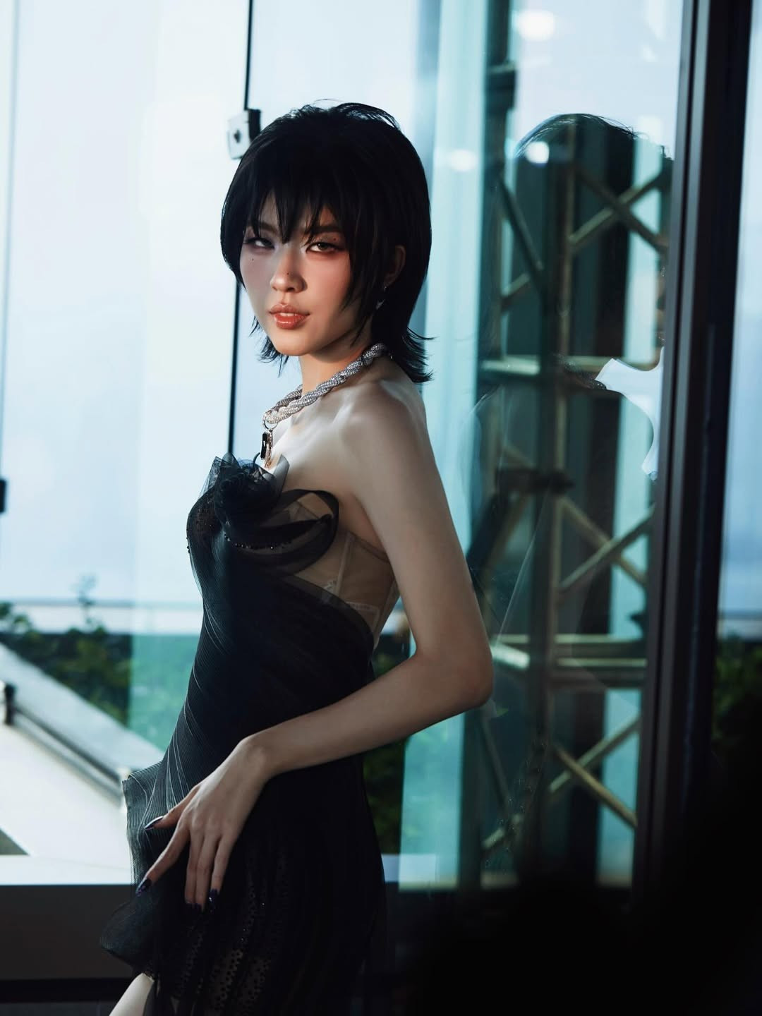 Vẻ đẹp của Lamoon trong loạt ảnh khiến người xem không khỏi ấn tượng bởi gương mặt góc cạnh nhưng mềm mại, được tô điểm bằng lớp makeup sắc nét tập trung ở đôi mắt, tạo nên ánh nhìn quyến rũ và có phần nổi loạn. Làn da sáng mịn nổi bật dưới ánh sáng tự nhiên, tương phản hoàn hảo với sắc đen của trang phục.