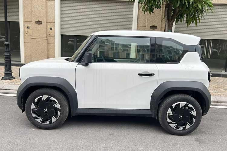 Về diện mạo tổng thể, VinFast VF3 Plus vẫn giữ nguyên kích thước nhỏ gọn và phong cách hình khối đặc trưng. Tuy nhiên, điểm nhận diện dễ dàng nhất nằm ở bộ mâm xe. Thay vì để lộ mâm sắt đơn điệu như các phiên bản trước, bản Plus được trang bị thêm ốp mâm bằng nhựa phối hai tông màu bắt mắt.