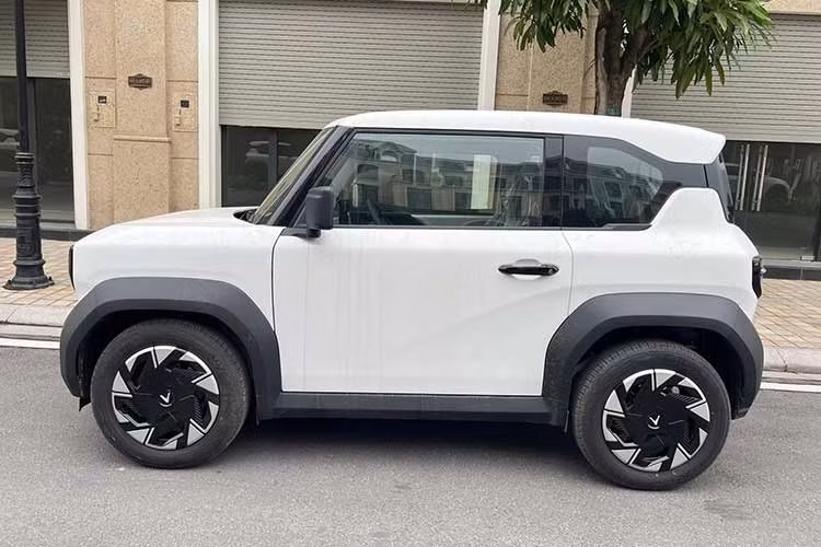 Về diện mạo tổng thể, VinFast VF3 Plus vẫn giữ nguyên kích thước nhỏ gọn và phong cách hình khối đặc trưng. Tuy nhiên, điểm nhận diện dễ dàng nhất nằm ở bộ mâm xe. Thay vì để lộ mâm sắt đơn điệu như các phiên bản trước, bản Plus được trang bị thêm ốp mâm bằng nhựa phối hai tông màu bắt mắt.