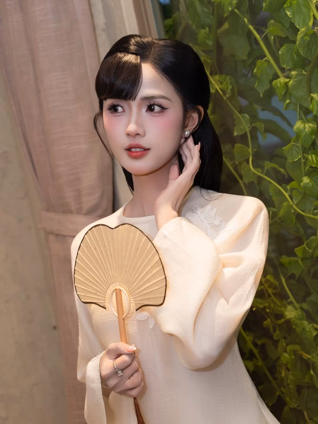 Tại sự kiện điện ảnh quy tụ đông đảo nghệ sĩ và khách mời, Gabriella Bùi lựa chọn một thiết kế áo dài tông trắng kem nhẹ nhàng, điểm xuyết họa tiết thêu nổi tinh tế ở phần thân trên. Phom dáng suông mềm mại kết hợp cùng chất liệu vải mỏng nhẹ giúp tổng thể trang phục vừa giữ được nét truyền thống, vừa mang hơi thở hiện đại, phù hợp với không gian trang trọng của buổi ra mắt phim.