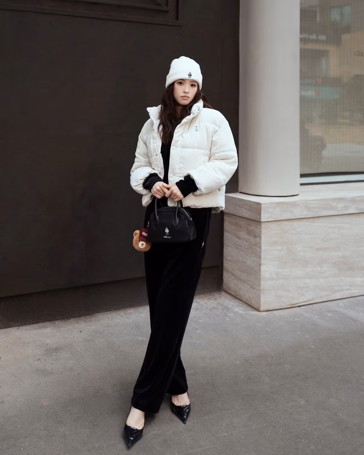 Set đồ đơn giản chỉ 2 màu đen trắng nhưng cách mix match tinh tế với mũ len, túi xách cùng tông màu và thần thái khiến bộ đồ của Tiểu Vy trở nên thời thượng.