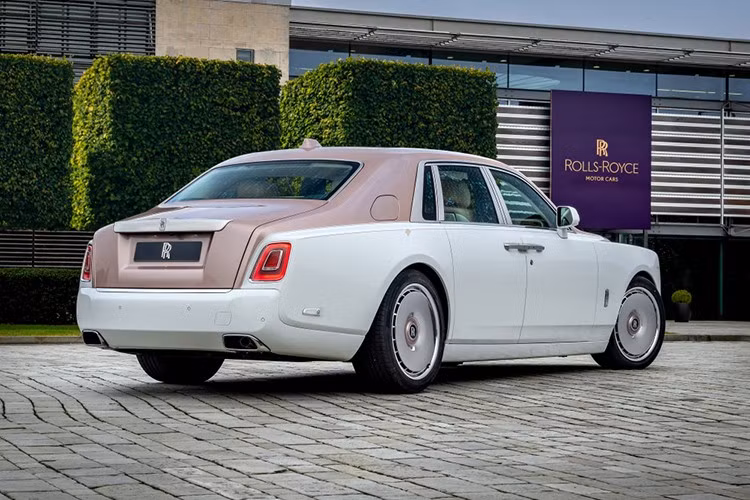 Tấm lưới tản nhiệt Pantheon được đánh sáng bóng, phía trên là biểu tượng Spirit of Ecstasy chế tác đặc biệt màu vàng hồng. Bậc cửa Bespoke khắc chữ tinh xảo cũng được hoàn thiện bằng màu sắc này nhằm tạo sự đồng bộ.