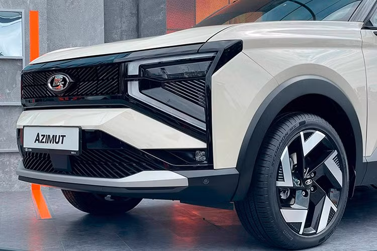 Azimut 2026 mới sở hữu thiết kế ngoại hình khác biệt với những mẫu Lada truyền thống, mạnh mẽ và hiện đại hơn. Mặt trước nổi bật với lưới tản nhiệt tạo hình chữ X đặc trưng, cụm đèn pha LED nối liền với hốc gió lớn. Phần thân xe sử dụng nhiều đường cắt dứt khoát trên chắn bùn, kết hợp mâm hợp kim 18 inch hai tông màu.