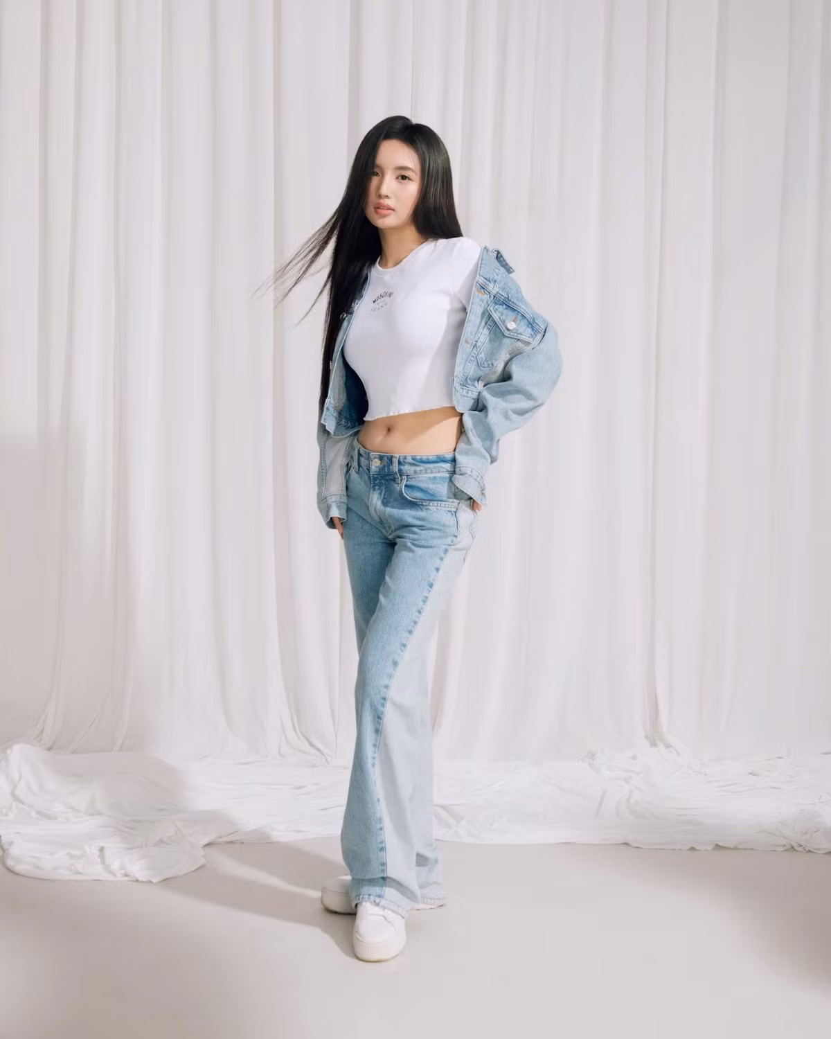 Diện nguyên cây denim trẻ trung với áo croptop trắng và jacket jeans khoác hờ, Ngân Hà tự tin khoe vòng eo con kiến cùng đôi chân dài thẳng tắp.