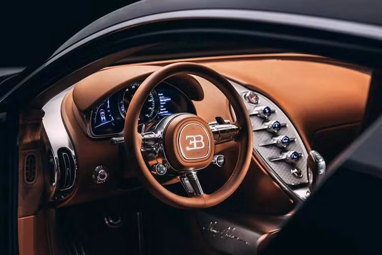Bên trong, vô lăng và bảng điều khiển trung tâm bằng nhôm được chế tác từ một khối kim loại nguyên khối. Và thay vì bọc da toàn bộ, Bugatti sử dụng chất liệu vải dệt tùy chỉnh được phát triển tại Paris, mang đến cho cabin cảm giác ấm áp và tinh tế hơn.