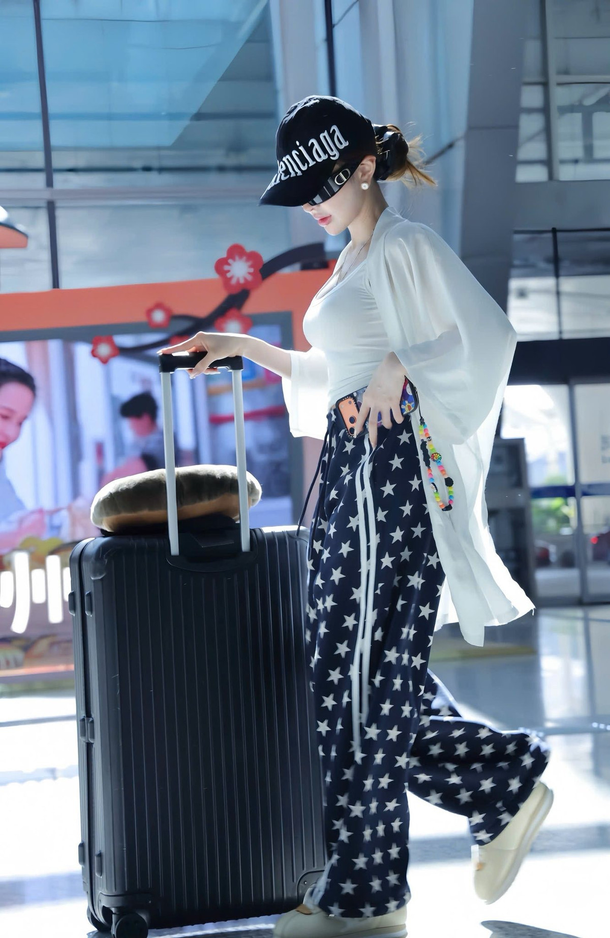 Trong ánh sáng lạnh của sân bay, gương mặt Trang Nemo trông nổi bật với làn da sáng, đường nét gọn gàng, đôi môi cong nhẹ cùng thần thái lạnh lùng phía sau cặp kính râm. Dù chỉ diện trang phục đơn giản, vẻ ngoài của cô vẫn toát lên khí chất của một nhân vật quen thuộc với ống kính.