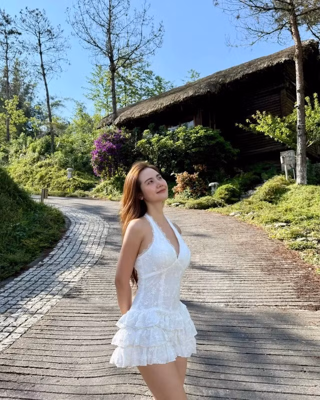 Thiết kế váy trắng với phần chân váy xếp tầng đã mang đến nét ngọt ngào, xen lẫn vẻ yêu kiều cho Huyền Lizzie.