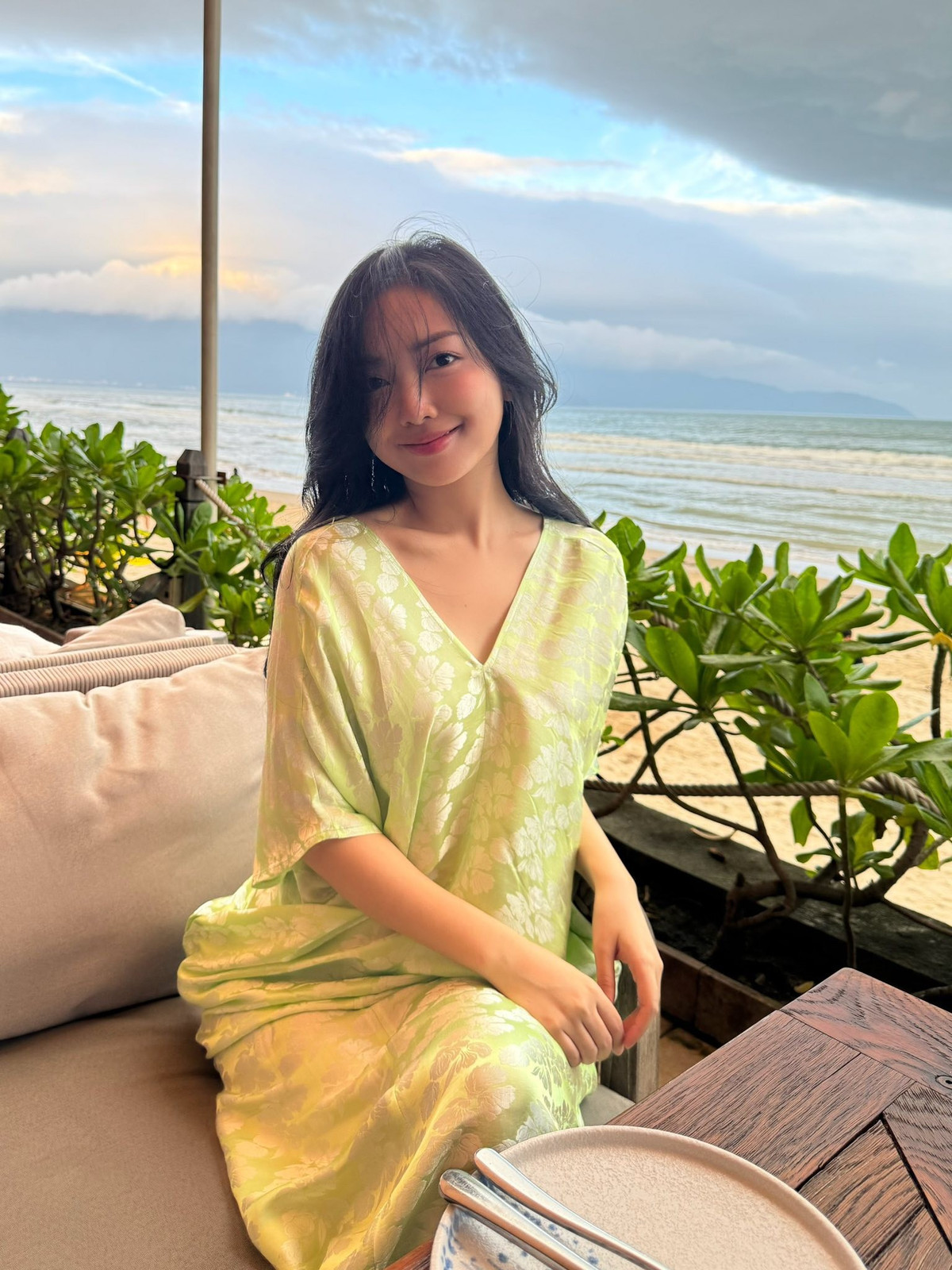 Mái tóc đen buông xoã, đôi khi được gió biển thổi tung, tạo nên vẻ đẹp cuốn hút rất tự nhiên. Trong khung cảnh biển chiều lãng mạn, Hà Trang hiện lên như một “nàng thơ mùa hạ”, vừa thanh lịch vừa đầy sức sống. Góc chụp cận càng cho thấy gương mặt mộc mạc, tươi tắn, không cần cầu kỳ trang điểm nhưng vẫn thu hút ánh nhìn.