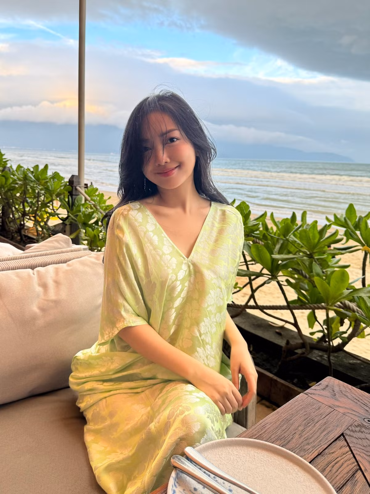 Mái tóc đen buông xoã, đôi khi được gió biển thổi tung, tạo nên vẻ đẹp cuốn hút rất tự nhiên. Trong khung cảnh biển chiều lãng mạn, Hà Trang hiện lên như một “nàng thơ mùa hạ”, vừa thanh lịch vừa đầy sức sống. Góc chụp cận càng cho thấy gương mặt mộc mạc, tươi tắn, không cần cầu kỳ trang điểm nhưng vẫn thu hút ánh nhìn.