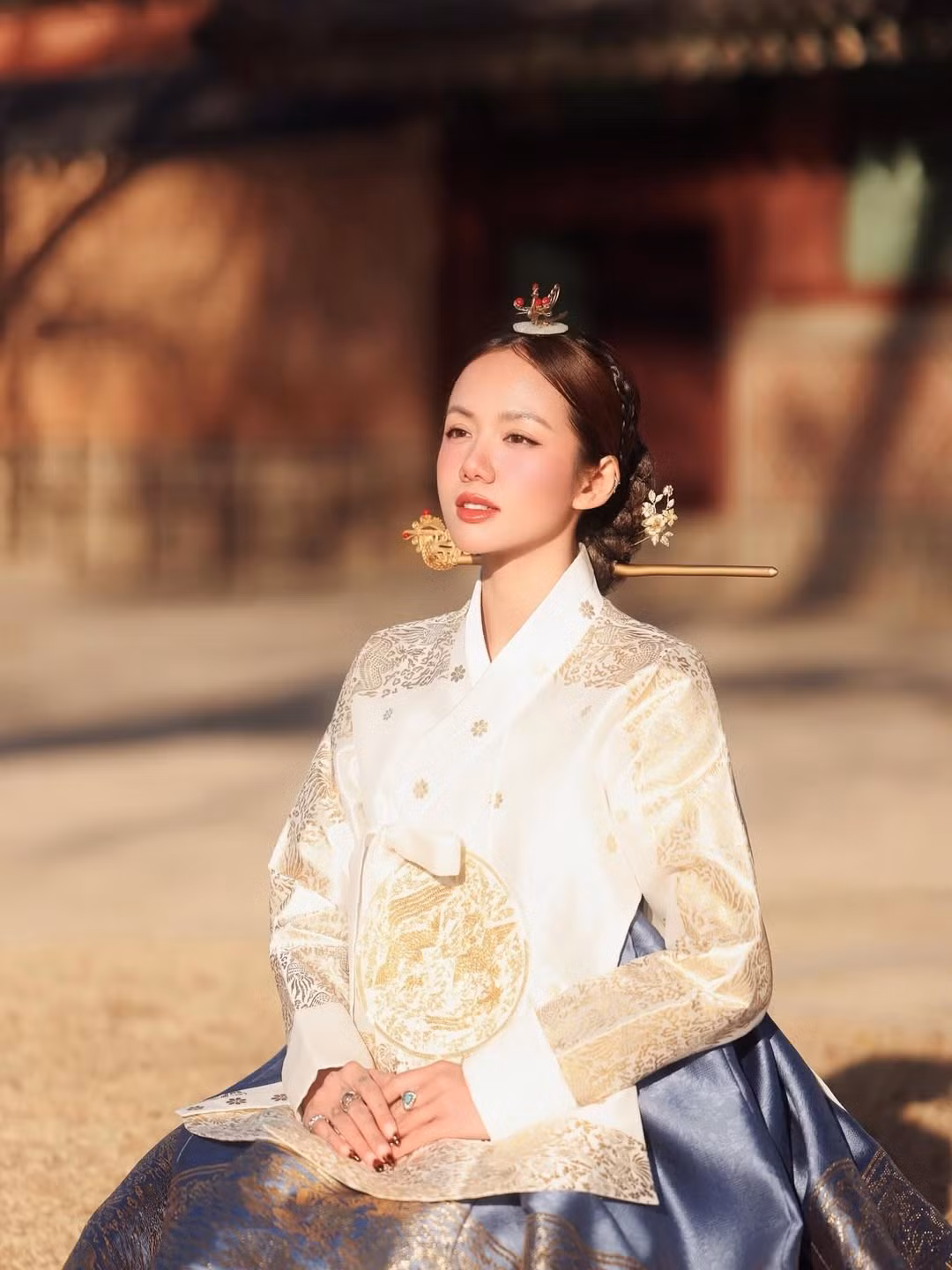 Gương mặt Phương Ly rạng rỡ nhưng thanh thoát, đường nét mềm mại, sống mũi cao và đôi mắt long lanh tạo cảm giác vừa sắc sảo vừa nhẹ nhàng. Lớp trang điểm trong trẻo với đôi má ửng hồng và đôi môi đỏ trầm khiến nữ ca sĩ trông cổ điển mà vẫn hiện đại.