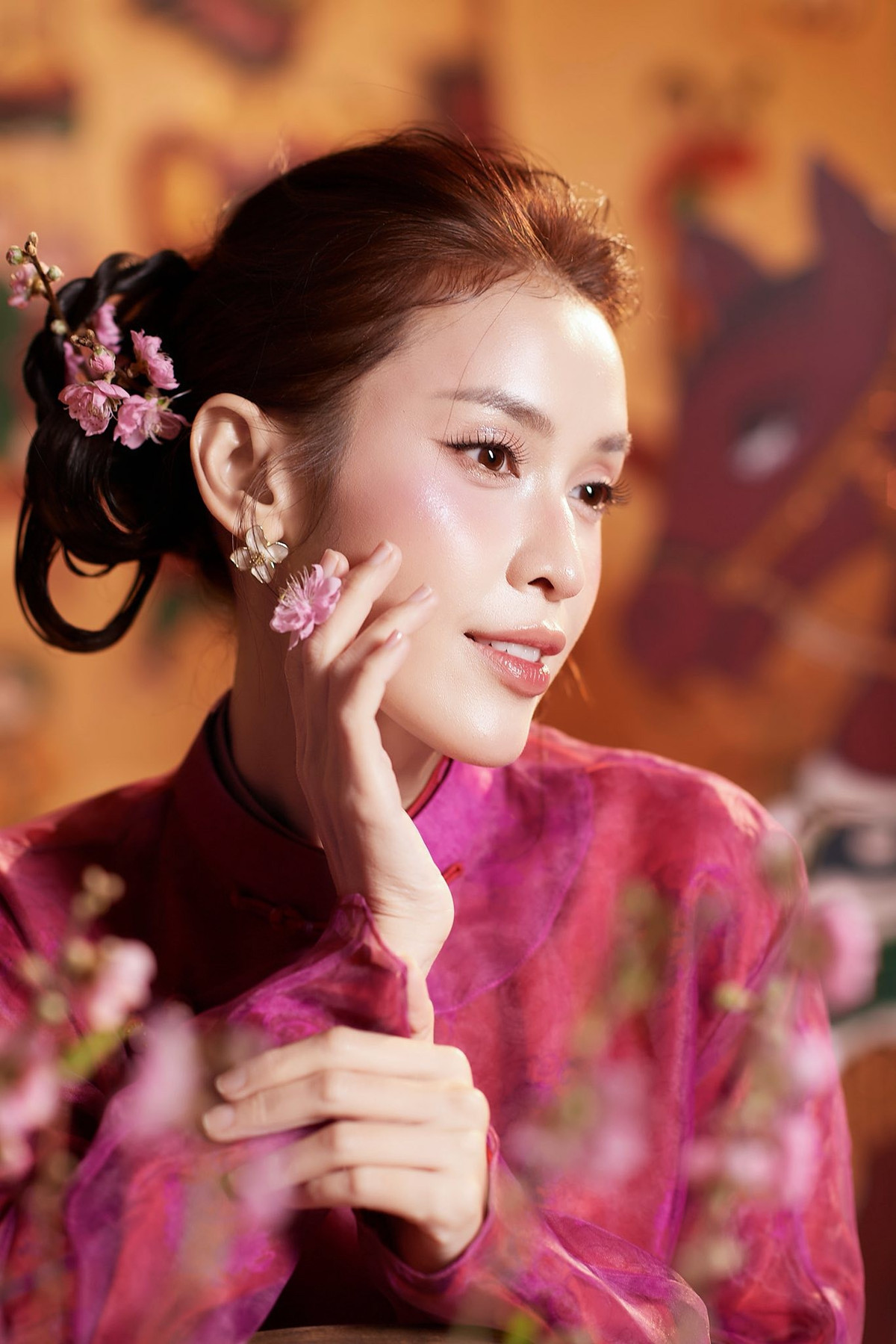 Trong loạt hình mới được thực hiện trong không gian mang hơi thở văn hóa truyền thống, Lê Tú Vi lựa chọn thiết kế áo dài tông hồng tím nổi bật. Chất liệu lụa mềm mại kết hợp lớp voan mỏng phía sau tạo hiệu ứng bay nhẹ, giúp tổng thể trang phục vừa nền nã vừa hiện đại. Gam màu tươi tắn không chỉ tôn nước da mà còn làm nổi bật nét nữ tính, dịu dàng của người đẹp.