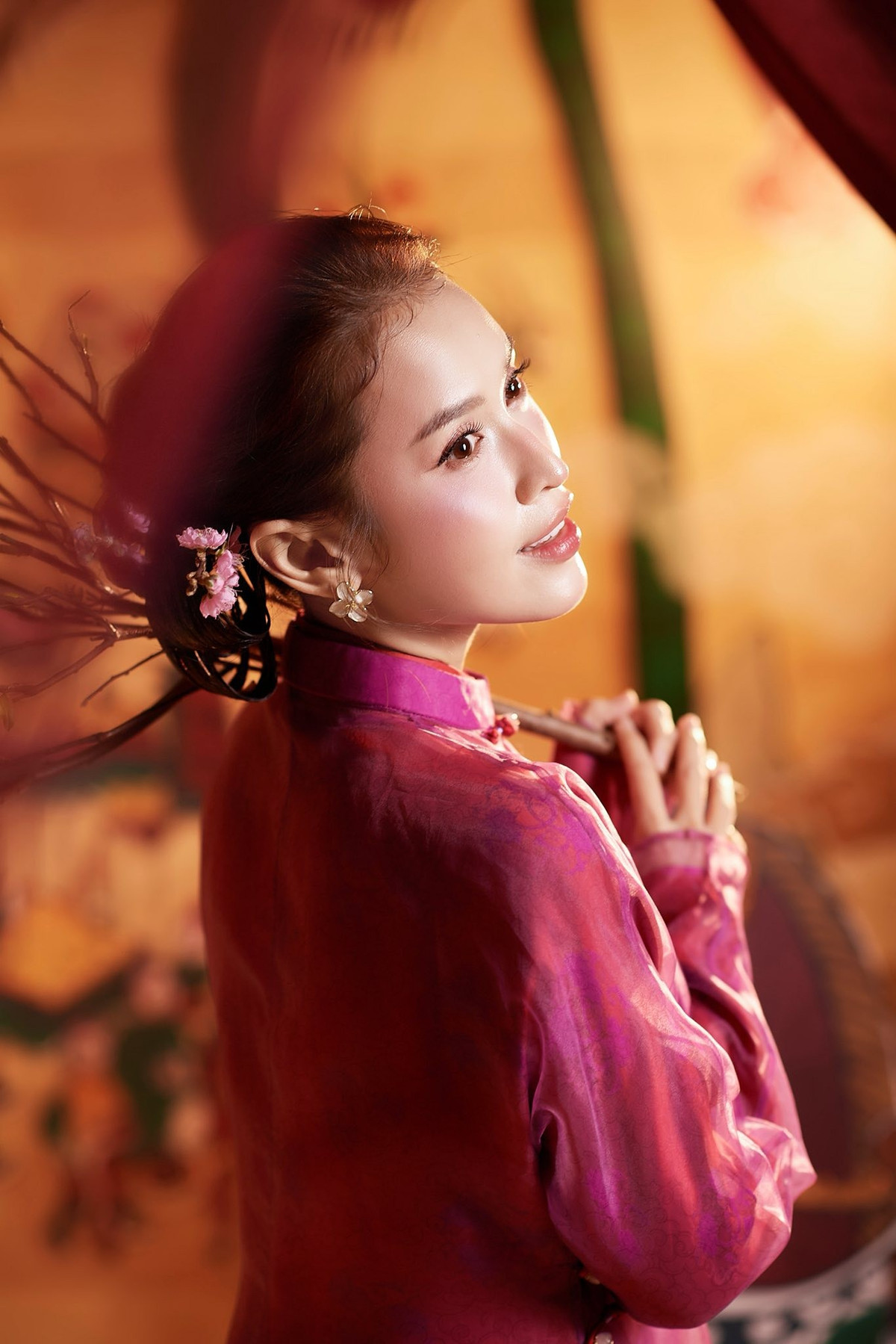 Trong một số bức ảnh, người đẹp còn tạo dáng bên mô hình ngựa gỗ và cành đào, mang lại cảm giác như bước ra từ không gian Tết xưa. Cách tạo dáng nhẹ nhàng, tiết chế giúp tôn lên vẻ đẹp tự nhiên thay vì phô trương. Chính sự giản dị này lại khiến bộ ảnh thêm phần cuốn hút.