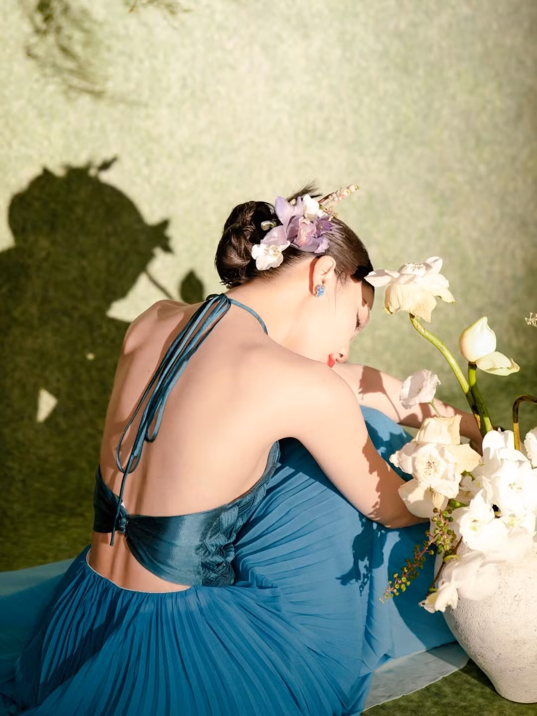 Chiếc váy yếm màu xanh pastel không chỉ giúp Ngọc Trinh khoe trọn bờ vai trần mảnh mai và tấm lưng ong quyến rũ, mà còn làm nổi bật làn da trắng mịn không tì vết.