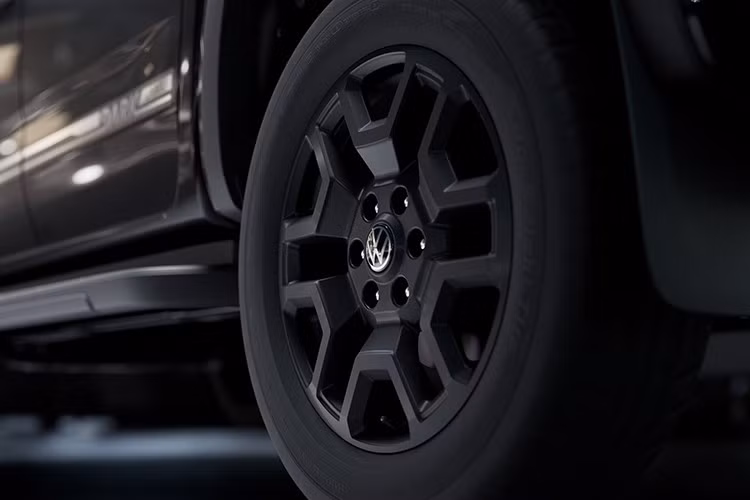 Volkswagen Amarok Dark Label 2026 sở hữu bộ mâm 20 inch màu đen mờ, dòng chữ đặc biệt, lưới tản nhiệt điểm xuyết màu đen và lớp bảo vệ gầm xe. Logo V6 được trang trí nổi bật, hé lộ động cơ nằm dưới nắp capo.