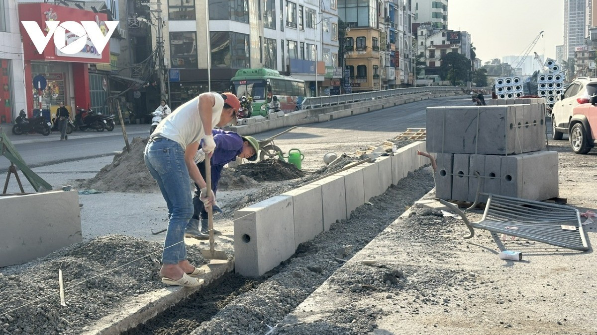 Công nhân đang thi công dải phân cách lối lên xuống hầm chui phía đường Giải Phóng.