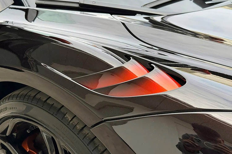 McLaren 750S Spider MSO Orange Coriolis có sự tương phản giữa sắc cam đặc trưng của McLaren và nền tối tái hiện dòng khí xoáy mạnh từ đầu xe, lướt dọc thân và tỏa ra phía sau khi tăng tốc.