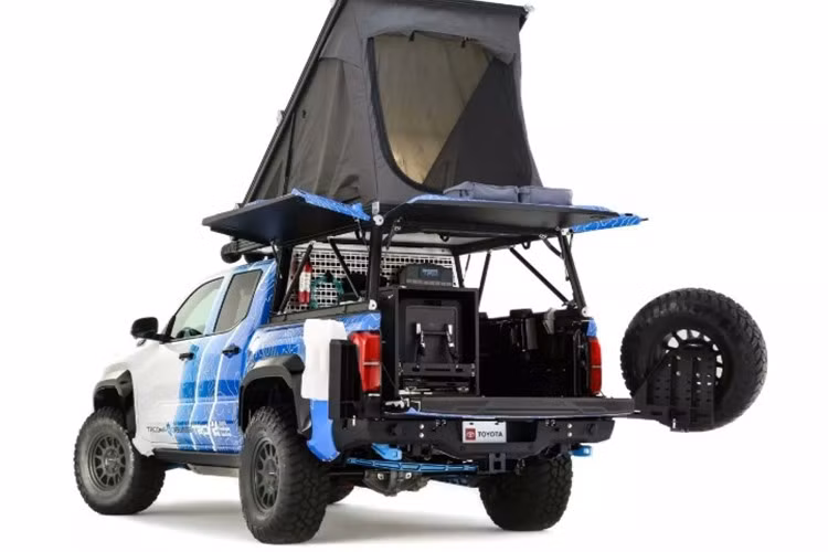 Phía sau xe, Toyota bố trí bộ lều mui bật cùng thùng xe có nắp mở ba hướng, biến Tacoma H2 thành “nhà di động” đúng nghĩa cho những chuyến cắm trại dài ngày. Cửa thùng sau được thiết kế theo dạng “roboformed”, vừa đảm bảo độ cứng, vừa tích hợp bánh dự phòng cỡ lớn để tăng tính thực tiễn.