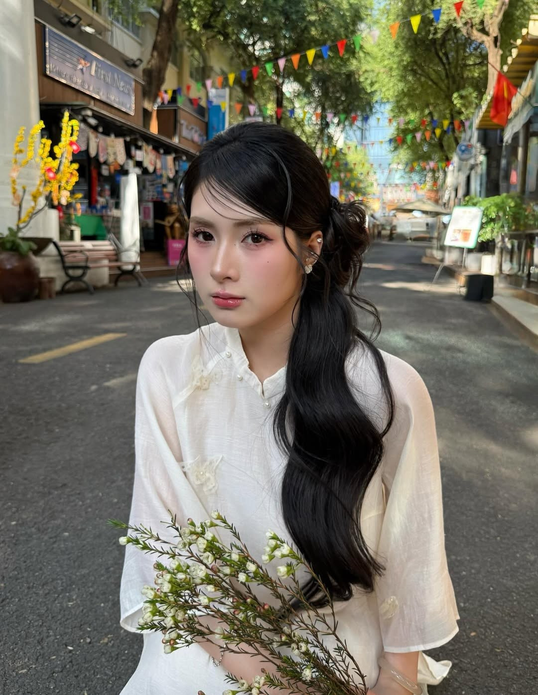 Trong bộ ảnh mới, Quỳnh Alee lựa chọn áo dài tông trắng kem nhẹ nhàng, chất liệu mỏng mềm, phom dáng suông tạo cảm giác bay bổng. Thiết kế tối giản, điểm xuyết họa tiết hoa nhỏ tinh tế giúp tổng thể trang phục thêm phần nền nã, đúng tinh thần ngày Tết.