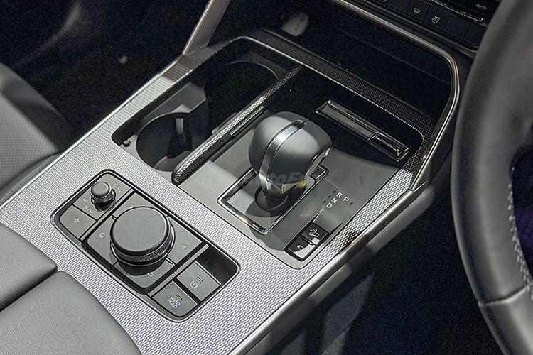 Ghế ngồi trên xe được bọc da màu đen, đục lỗ thông hơi và thêu chỉ màu vàng đồng. Xe có ghế trước chỉnh điện, ghế lái có nhớ vị trí nhưng không còn tính năng làm mát như bản cao cấp. Hàng ghế sau trang bị cửa gió riêng, cổng sạc USB, tựa tay trung tâm và có thể ngả hai nấc, đây là cải tiến đáng giá so với CX-5.