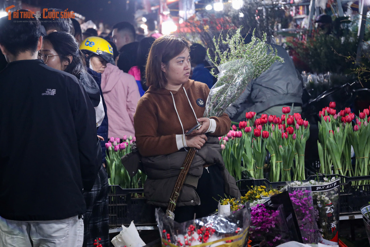 Bên trong chợ, các quầy hoa sáng đèn suốt đêm. Tiểu thương liên tục bốc dỡ hàng, phân loại hoa, chào mời khách. Nhiều điểm bán đông kín người, khách phải xếp hàng chờ đến lượt lựa chọn, thanh toán. Không khí khẩn trương hiện rõ trên từng gương mặt, bởi ai cũng muốn nhanh chóng chọn được những bó hoa ưng ý nhất giữa “biển hoa” rực rỡ.