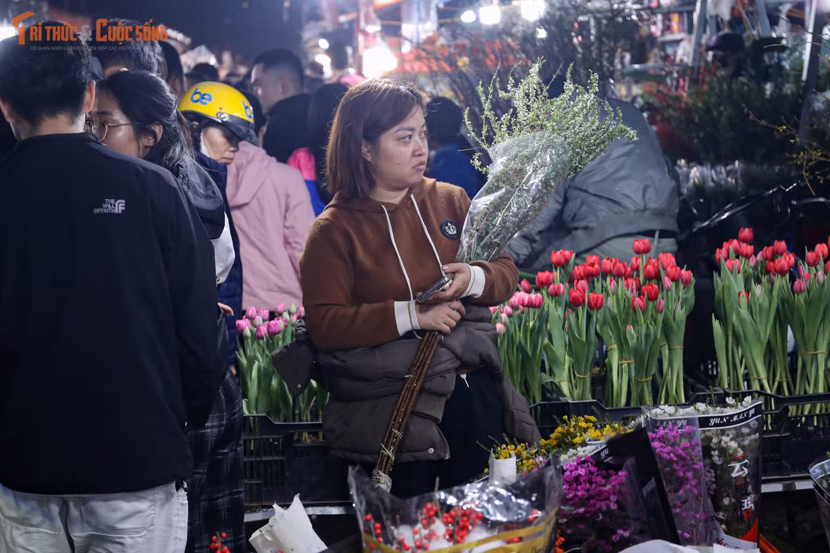 Bên trong chợ, các quầy hoa sáng đèn suốt đêm. Tiểu thương liên tục bốc dỡ hàng, phân loại hoa, chào mời khách. Nhiều điểm bán đông kín người, khách phải xếp hàng chờ đến lượt lựa chọn, thanh toán. Không khí khẩn trương hiện rõ trên từng gương mặt, bởi ai cũng muốn nhanh chóng chọn được những bó hoa ưng ý nhất giữa “biển hoa” rực rỡ.