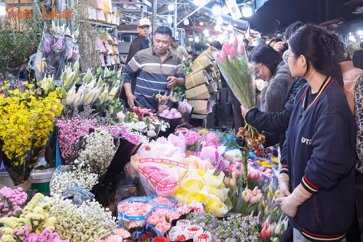 Dòng phương tiện ra vào chợ nối dài, nhiều thời điểm giao thông rơi vào tình trạng ùn ứ kéo dài. Xe tải, xe ba gác, xe máy chở hoa nối đuôi nhau, chất đầy ly, lay ơn, đào, mộc lan… tạo nên khung cảnh đặc trưng chỉ có ở chợ hoa đêm giáp Tết. Việc di chuyển trở nên khó khăn, nhưng dường như không làm giảm nhiệt của dòng người đổ về mua sắm.