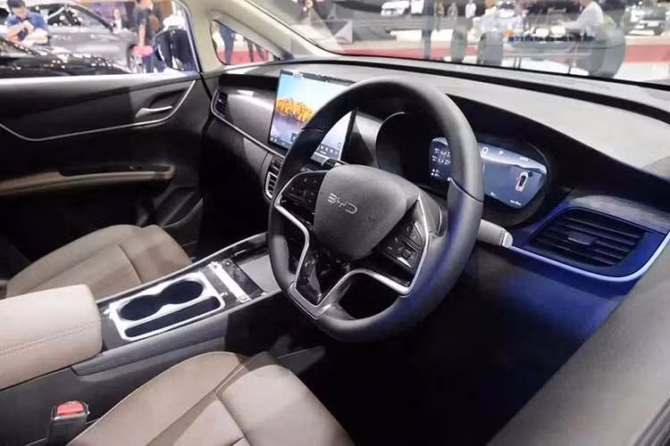 Bên trong xe, BYD M6 DM vẫn giữ phong cách nội thất thực dụng của bản thuần điện nhưng có một số thay đổi đáng chú ý, đặc biệt là cần số được chuyển từ bệ trung tâm lên cột lái. Thiết kế này cùng cụm nút bấm vật lý mảnh hơn đã tạo thêm không gian cho hộc để điện thoại. Bản Cross Superior cao cấp nhất sẽ được trang bị sạc không dây Qi.