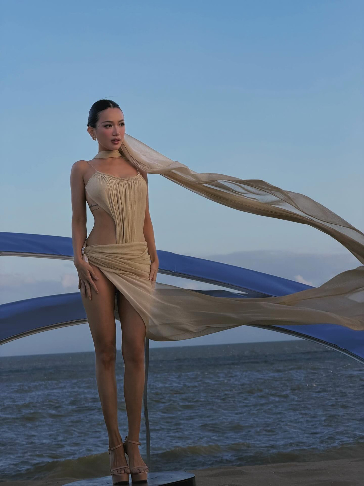 Không chỉ gây ấn tượng ở hình thể, thần thái của Sĩ Thanh cũng là yếu tố khiến bộ ảnh trở nên hút mắt. Khi thì cô thả dáng tự nhiên cùng mái tóc dài bay trong gió biển, lúc lại khẽ nhắm mắt tận hưởng nắng gió, tạo nên những khoảnh khắc vừa gợi cảm vừa đầy chất thơ. Ánh nhìn sắc sảo xen lẫn vẻ mềm mại nữ tính giúp mỗi khung hình đều mang cảm giác thời trang chuyên nghiệp như một bộ ảnh tạp chí.