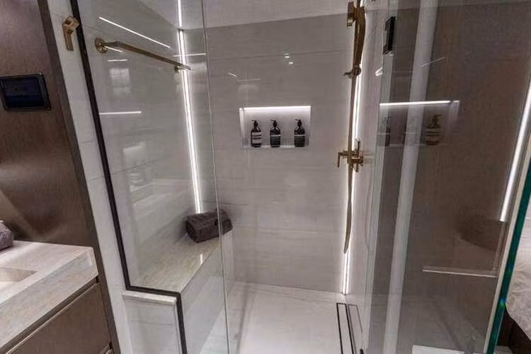 Những chi tiết tối ưu hóa trải nghiệm người dùng bao gồm ngăn để giấy vệ sinh được thiết kế kín đáo và khu vực trang điểm tích hợp gọn gàng trong ngăn kéo phía dưới bồn rửa mặt.