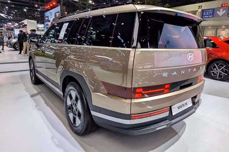 Ngoại hình SantaFe Hybrid 2026 tương tự bản động cơ đốt trong với tạo hình vuông vức, bề thế. Ngay từ phiên bản Exclusive tiêu chuẩn, xe đã sở hữu danh sách trang bị khá đầy đủ với đèn LED chạy ban ngày, đèn hậu LED, đèn chào mừng, kính chắn gió hai lớp và mâm 18 inch đi kèm cốp điện rảnh tay.
