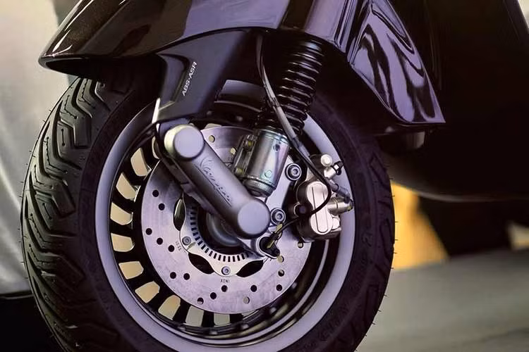 Điểm nhấn phân biệt bản đặc biệt Vespa Horse 2026 nằm ở biểu tượng hình móng ngựa mạ vàng ở ngay dưới yên và chữ V (tên hãng Vespa) ở trung tâm. Bộ kẹp phanh mạ vàng bánh trước tăng tính thẩm mĩ. Yên bọc da trang trí với chỉ màu vàng tương phản.