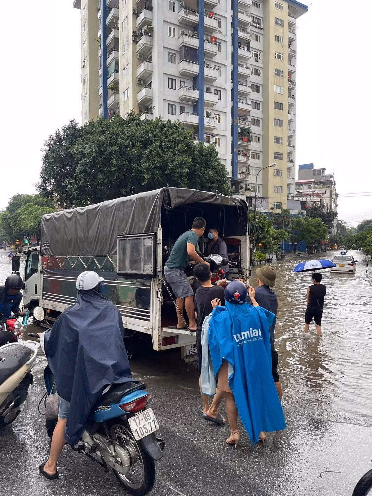 Tại khu vực phố Nguyễn Cảnh Dị - Hà Nội, nhiều người dân đã phải nhờ một số ô tô tải để có thể vượt qua đoạn ngập sâu.